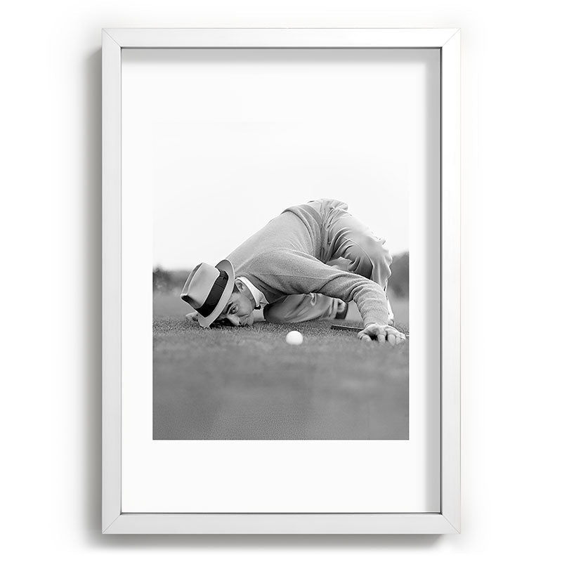 Eye to the ground on the 18th hole; golfing man eyes ball to measure distance to hole vintage black and white portrait photograph - photography - photographs poster Framed Art Print Gallery Image 105